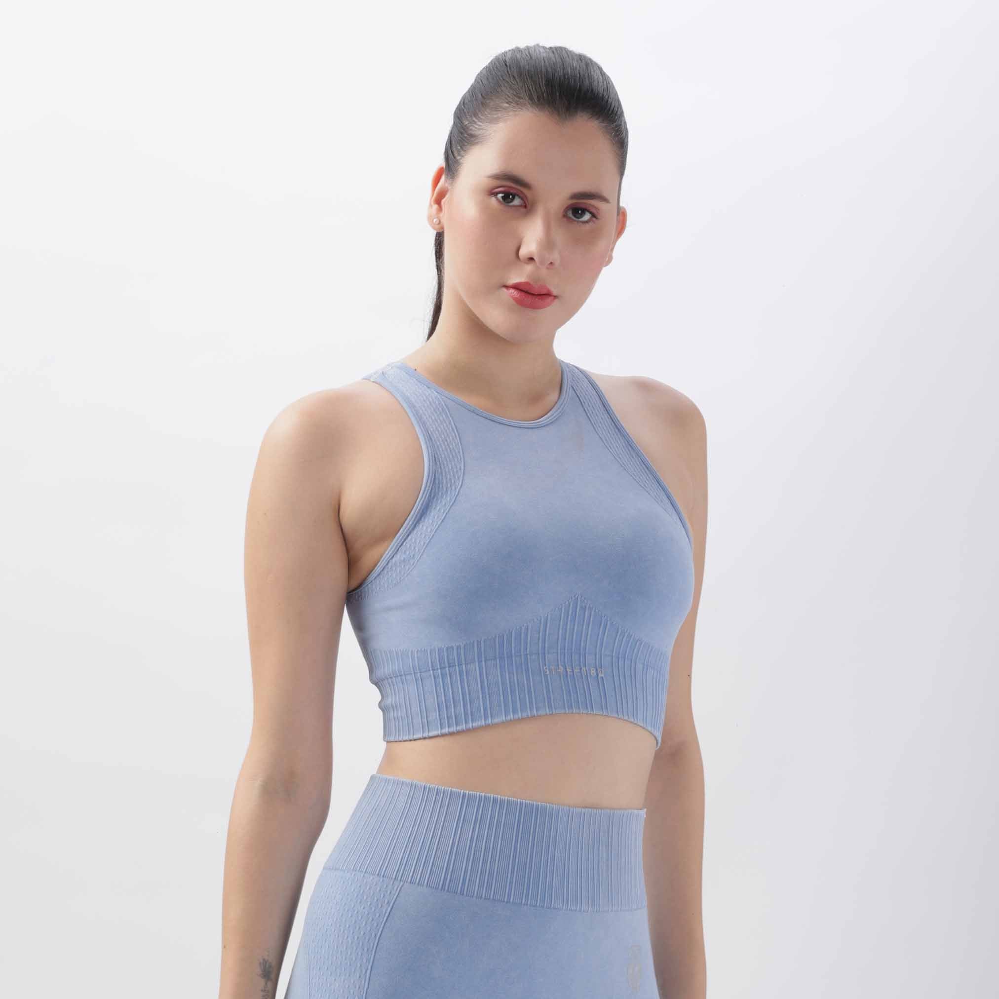 A woman wearing a blue knitted push-up sports bra fitness vest with a crop length and tight fit. The vest appears to be made of a stretchy fabric and has adjustable straps.